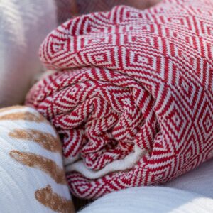 Rolled textile with red and white diamond pattern.